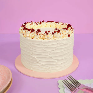 Vegan Red Velvet Cake by Crumbs & Doilies with smooth vegan buttercream and red velvet sponge crumbs on top.